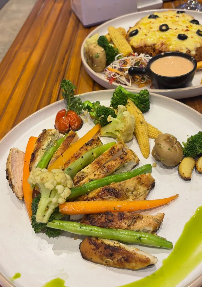 A plated grilled chicken dish with fresh seasonal vegetables